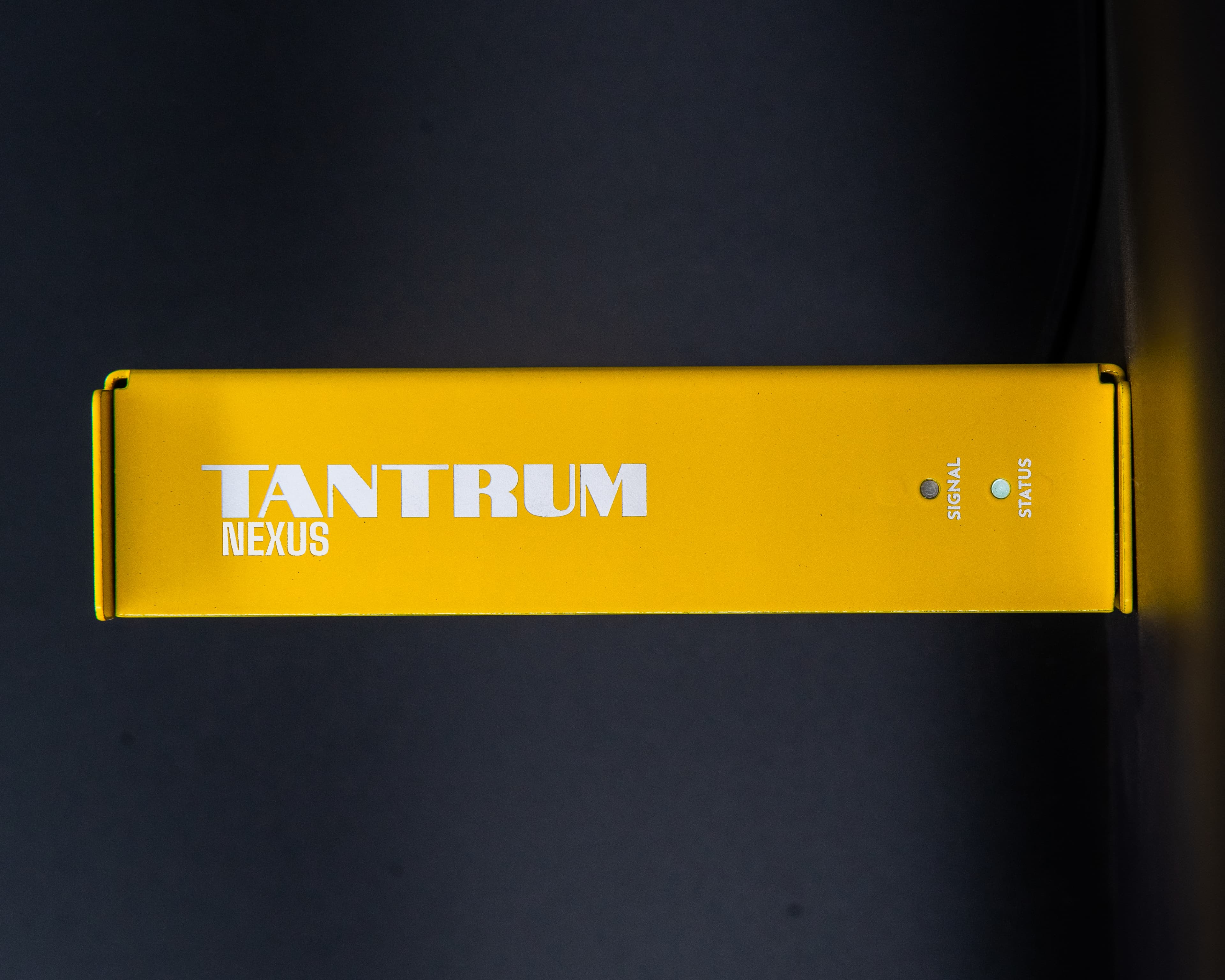 The front of a small rack-width DSP speaker processor on a dark surface.